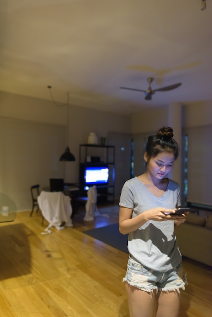 Portrait de la belle jeune femme asiatique se détendre dans le salon