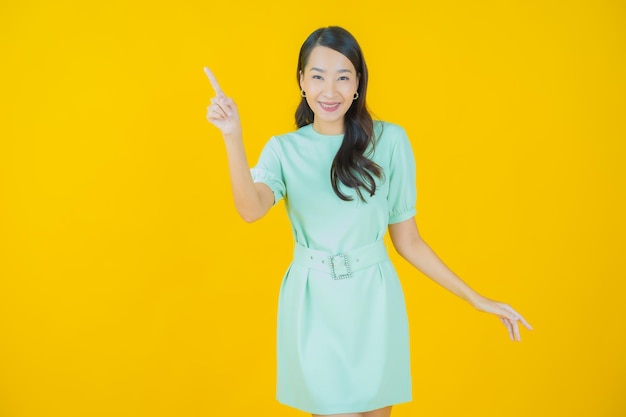 Portrait belle jeune femme asiatique sourire avec action sur fond de couleur