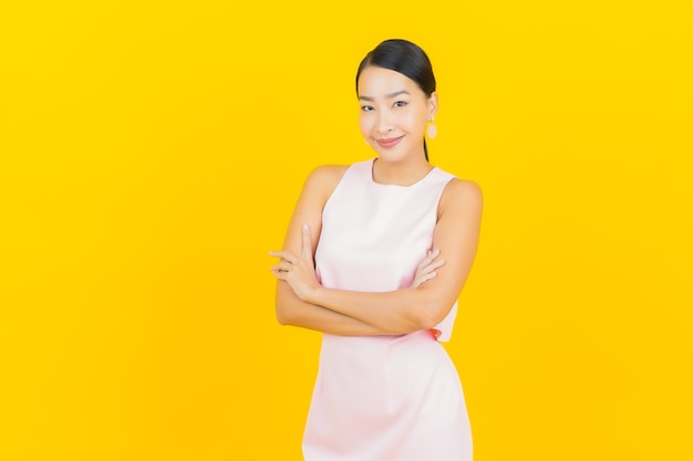 Portrait belle jeune femme asiatique sourire avec action sur jaune