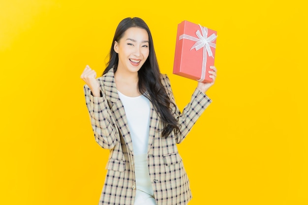 Portrait belle jeune femme asiatique sourire avec boîte-cadeau rouge