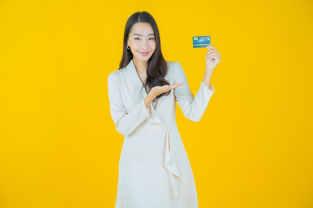 Portrait belle jeune femme asiatique sourire avec carte de crédit sur fond de couleur