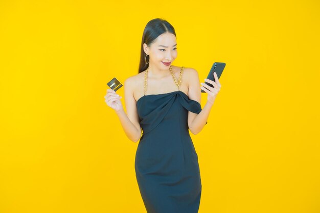 Portrait de la belle jeune femme asiatique sourire avec carte de crédit