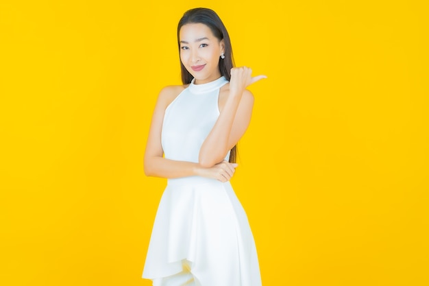 Portrait belle jeune femme asiatique sourire sur jaune