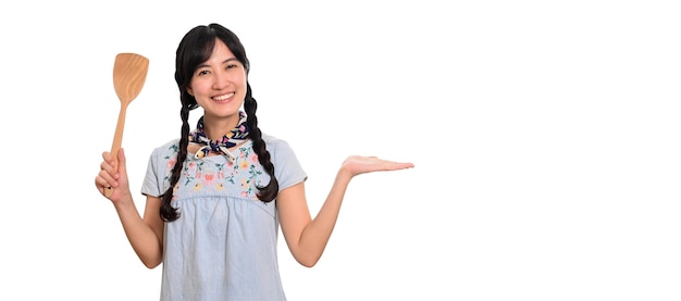 Portrait de la belle jeune femme asiatique sourire en robe denim avec spatule sur fond blanc