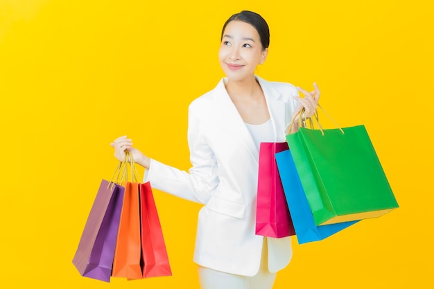 Portrait Belle Jeune Femme Asiatique Sourit Avec Des Sacs à Provisions Sur Mur De Couleur