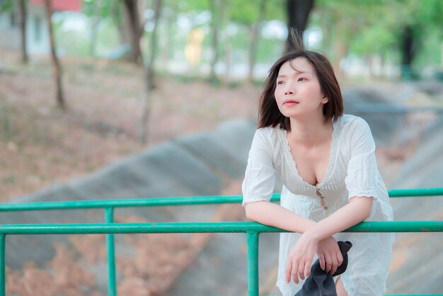 Portrait d'une belle jeune femme asiatique vêtue d'une robe blanche en plein airStyle de vie d'une femme moderne