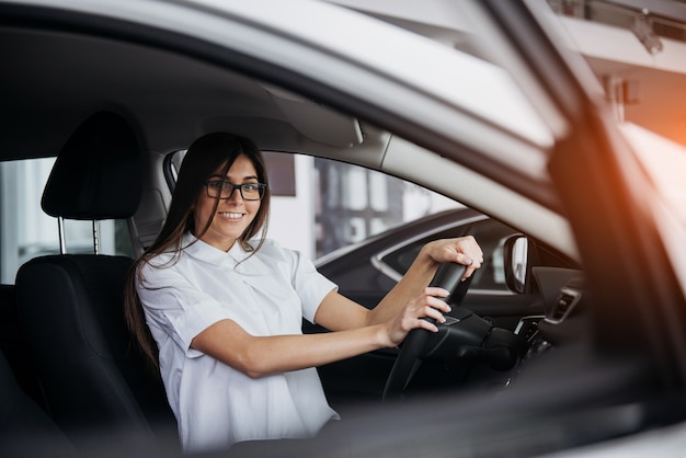 Portrait de la belle jeune femme assise dans la voiture