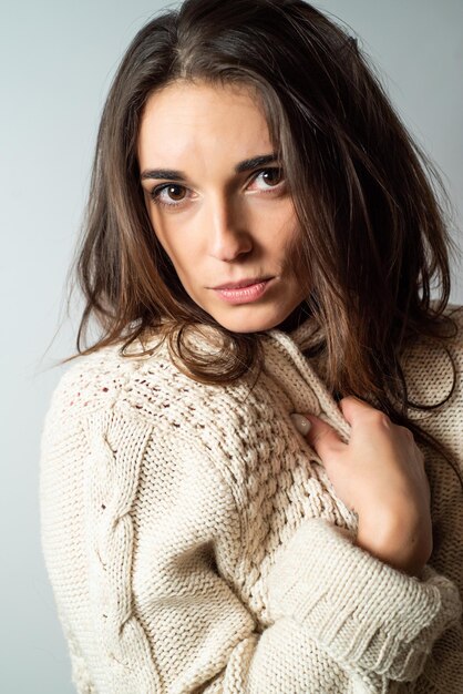 portrait d'une belle jeune femme aux cheveux longs dans un chandail douillet