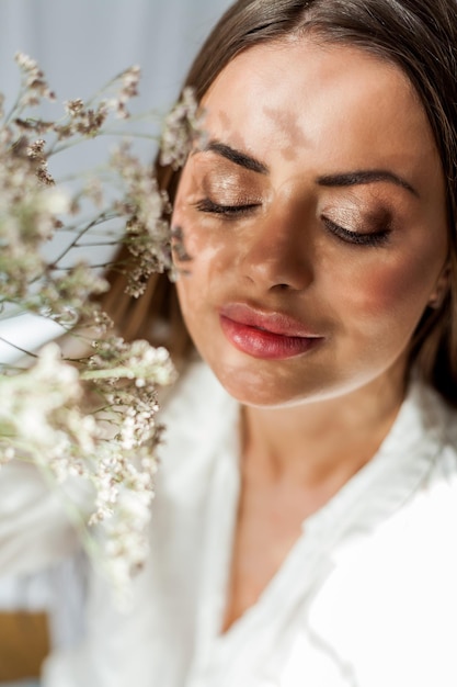 Portrait de la belle jeune femme aux cheveux longs sur fond blanc avec des fleurs séchées Ombre sur le visage de fleurs Printemps