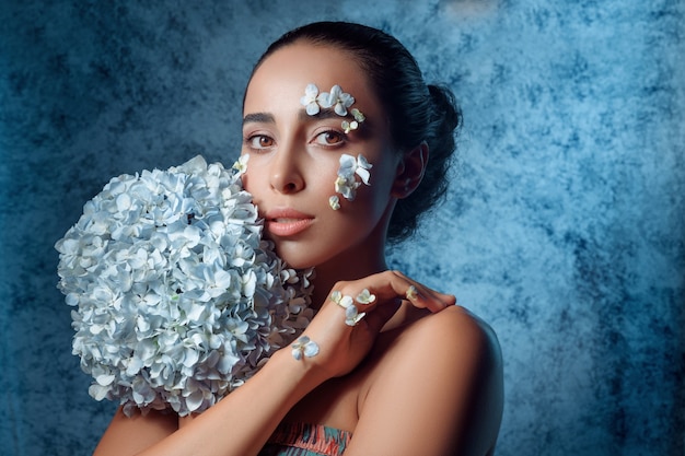 Portrait de la belle jeune femme aux fleurs bleues