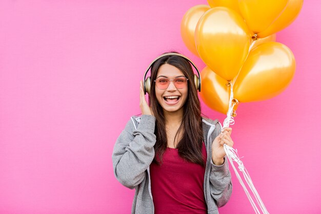 Portrait de la belle jeune femme avec des ballons d'or