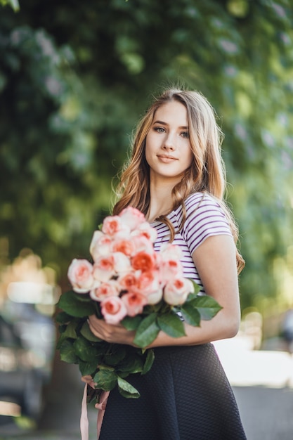 Portrait D'une Belle Jeune Femme Blonde Debout Avec Un Bouquet De Roses