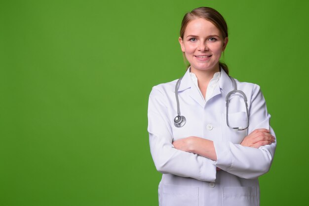 Portrait de la belle jeune femme blonde médecin sur vert