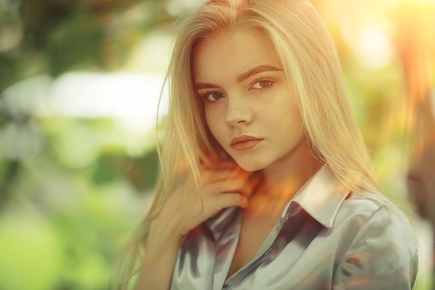 portrait d'une belle jeune femme blonde avec des rayons de soleil et des reflets