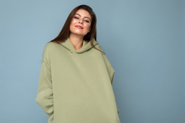 Portrait de la belle jeune femme brune souriante caucasienne modèle en sweat à capuche kaki tendance isolé