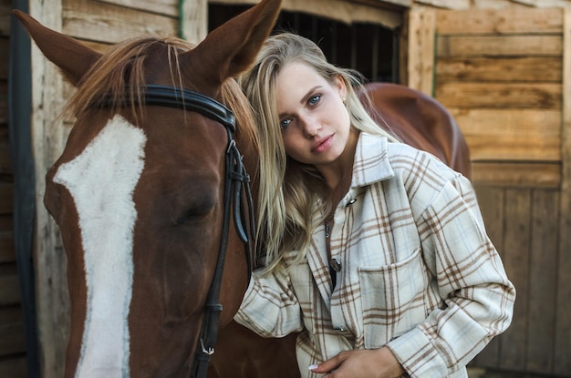 Portrait d'une belle jeune femme avec un cheval gros plan vertical