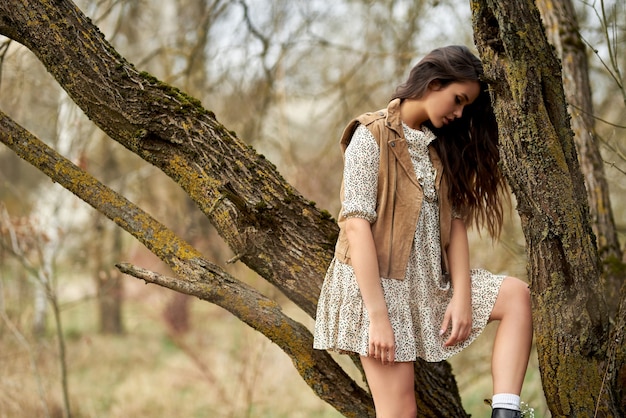 Photo portrait de la belle jeune femme dans les arbres de fleurs de printemps. arbres à fleurs printanières.