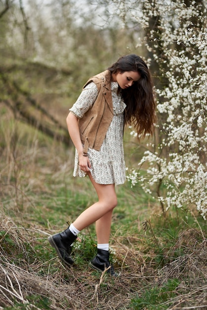 Portrait de la belle jeune femme dans les arbres de fleurs de printemps.