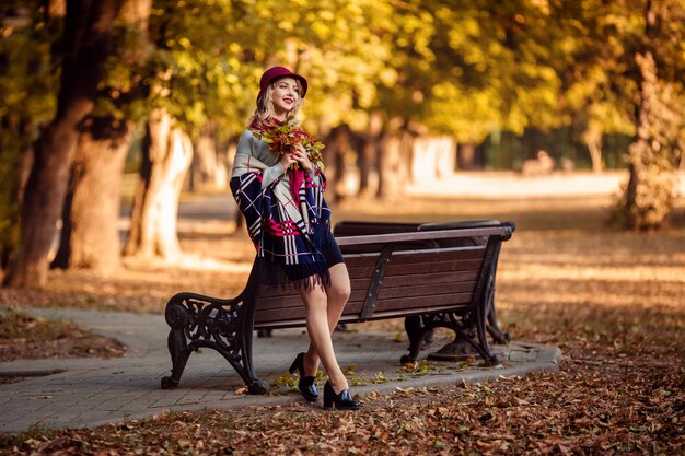 Portrait d'une belle jeune femme dans un chapeau bordeaux à l'automne lors d'une promenade dans le parc