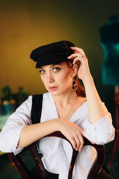 Portrait d'une belle jeune femme dans une chemise blanche et un pantalon noir à la maison