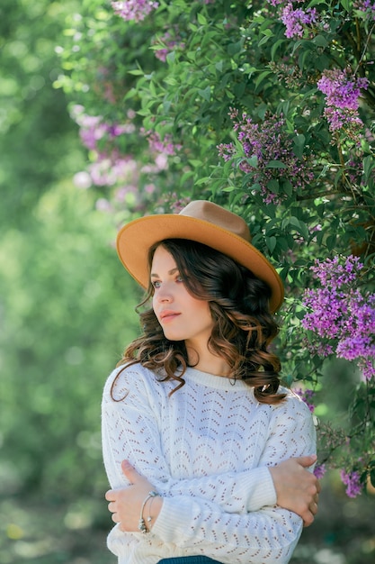 Portrait d'une belle jeune femme dans un parc de lilas en fleurs.