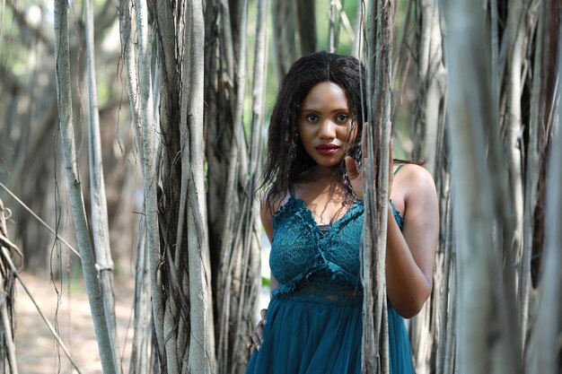 Portrait d'une belle jeune femme debout contre des arbres