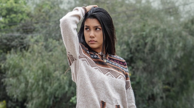 Photo portrait d'une belle jeune femme debout contre des arbres