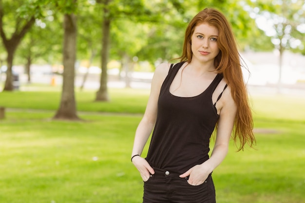 Portrait de belle jeune femme debout dans le parc