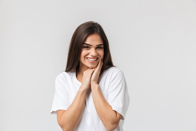 Portrait d'une belle jeune femme décontractée habillée debout isolé sur blanc