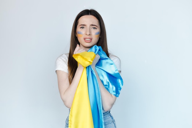 Portrait d'une belle jeune femme avec un drapeau ukrainien sur fond blanc Arrêtez la guerre en Ukraine