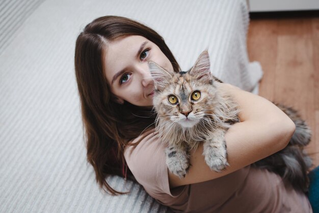 Portrait d'une belle jeune femme embrassant son chat à la maison
