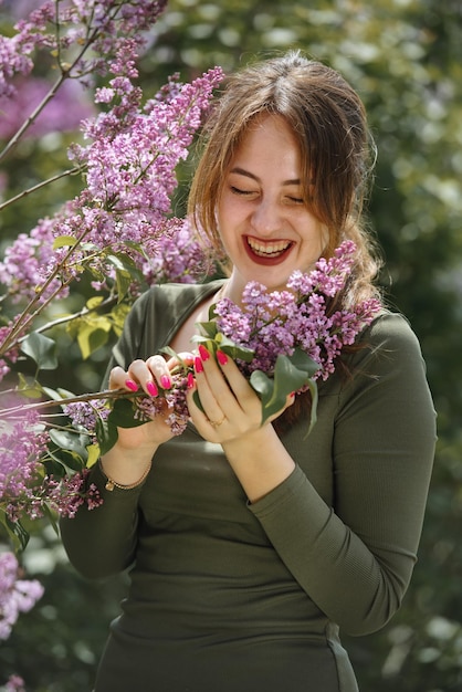 Portrait d'une belle jeune femme entourée de fleurs lilas