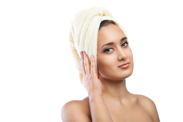 Portrait de belle jeune femme enveloppée dans une serviette après le bain. Spa. Isolé sur fond blanc