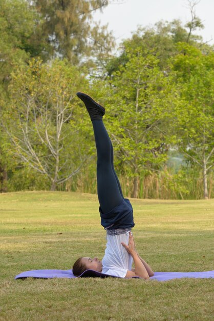 Portrait de la belle jeune femme exerçant dans le parc en plein air