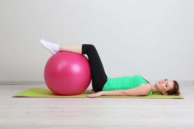 Portrait de la belle jeune femme exercices avec ballon de gym