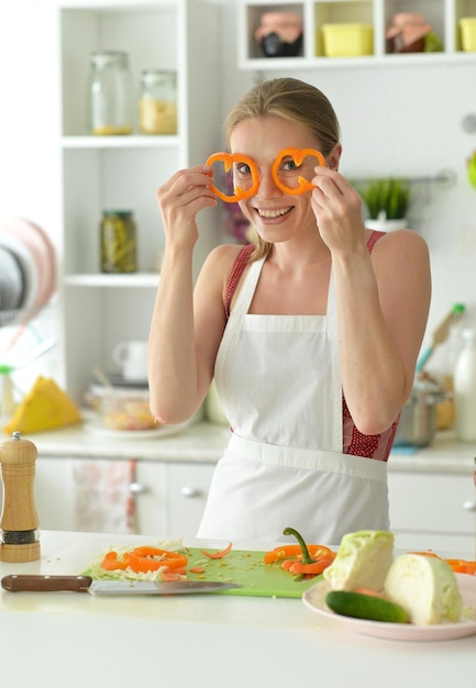 Portrait d'une belle jeune femme faisant cuire dans la cuisine