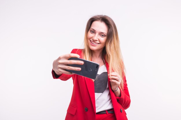 Portrait de belle jeune femme faisant selfie en costume rouge élégant