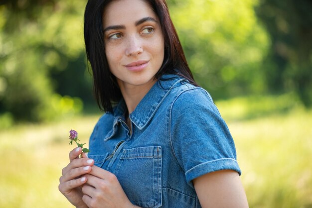 Portrait d'une belle jeune femme avec une fleur dans ses mains Promenade dans le parc