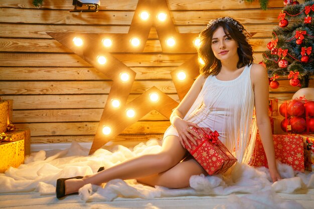 Portrait d&#39;une belle jeune femme sur le fond d&#39;un sapin de Noël