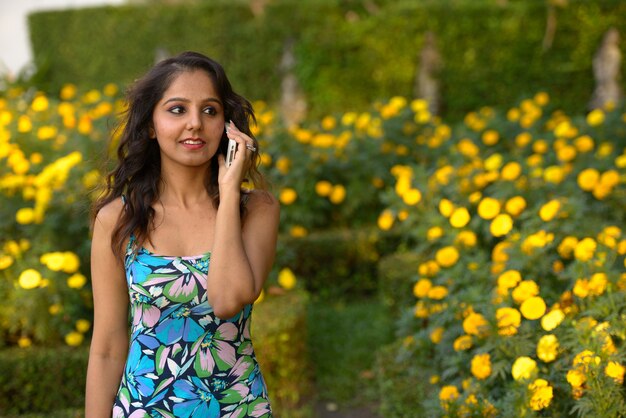 Portrait de la belle jeune femme indienne se détendre dans le parc en plein air