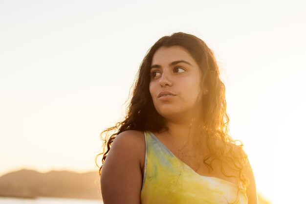 Portrait d'une belle jeune femme latine en bikini au coucher du soleil