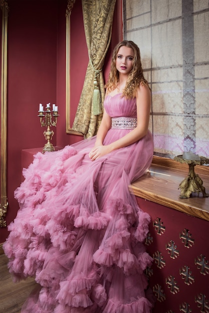 Photo portrait de belle jeune femme en longue robe rose