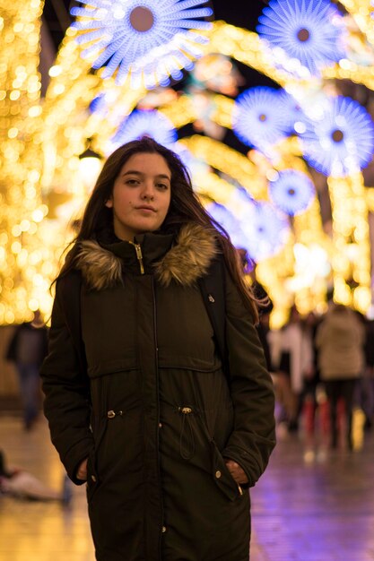 Portrait d'une belle jeune femme avec des lumières de Noël