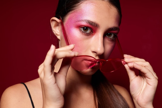 Portrait d'une belle jeune femme à lunettes roses maquillage émotions cosmétiques gros plan inchangé