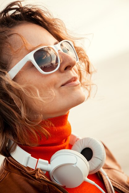 Photo portrait d'une belle jeune femme à lunettes de soleil avec un casque