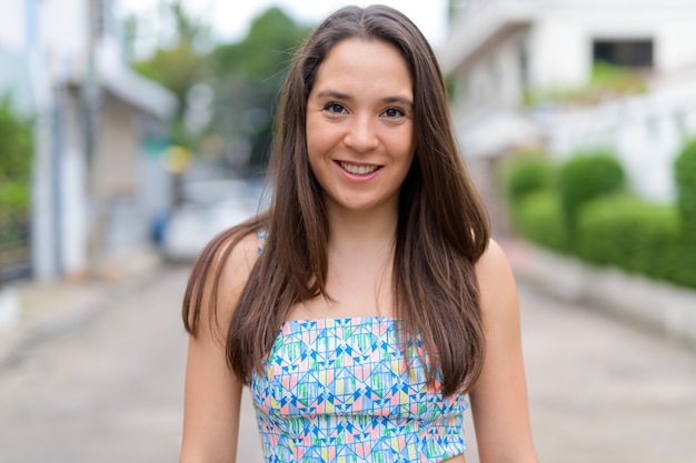 Portrait de la belle jeune femme multiethnique portant une robe d'été dans la rue