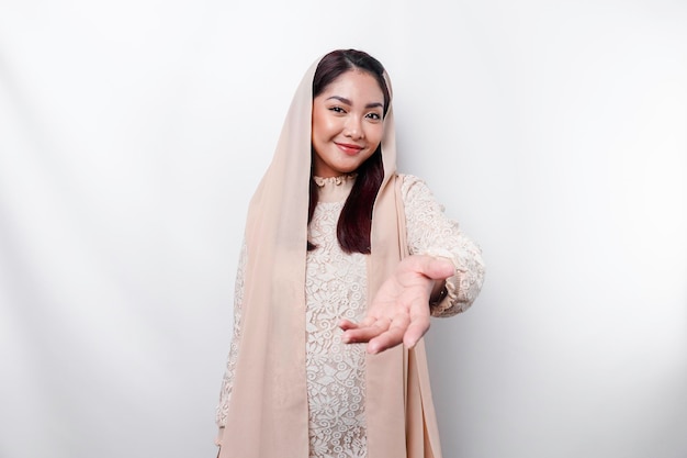 Portrait d'une belle jeune femme musulmane asiatique portant un foulard gesticulant Eid Mubarak salutation