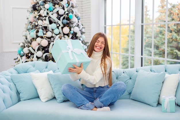 portrait d'une belle jeune femme à noël sur fond d'arbre de noël