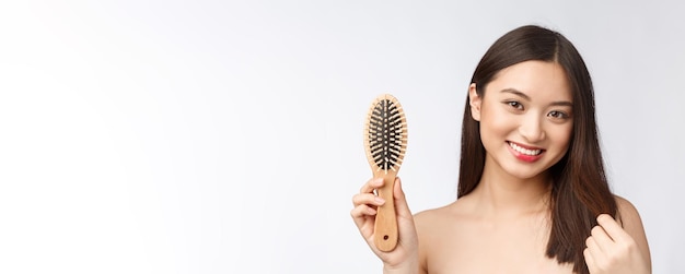 Portrait d'une belle jeune femme peigne cheveux magnifiques isolé sur fond blanc beauté asiatique