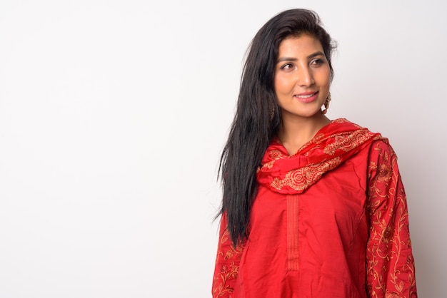 Portrait de la belle jeune femme persane portant des vêtements traditionnels contre le mur blanc